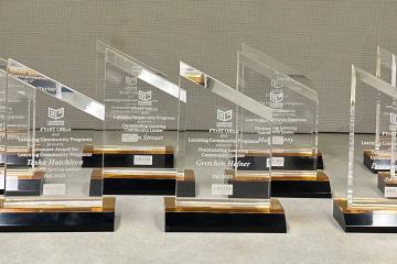 Glass trophies lined up on a white background