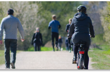 Individuals walk and ride bicycles outside