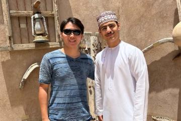 Two men stand in front of a building