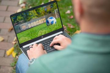 An OHIO Masters in Coaching Education - Soccer student on their laptop outside