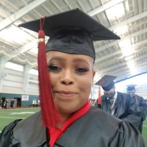Bridget Selotlegeng smiles in a selfie photo, wearing a cap and gown.