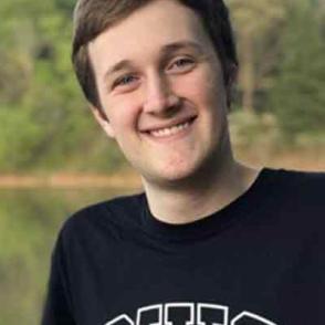 Noah Powell smiles with a lake in the background, wearing a black 'OHIO' shirt.