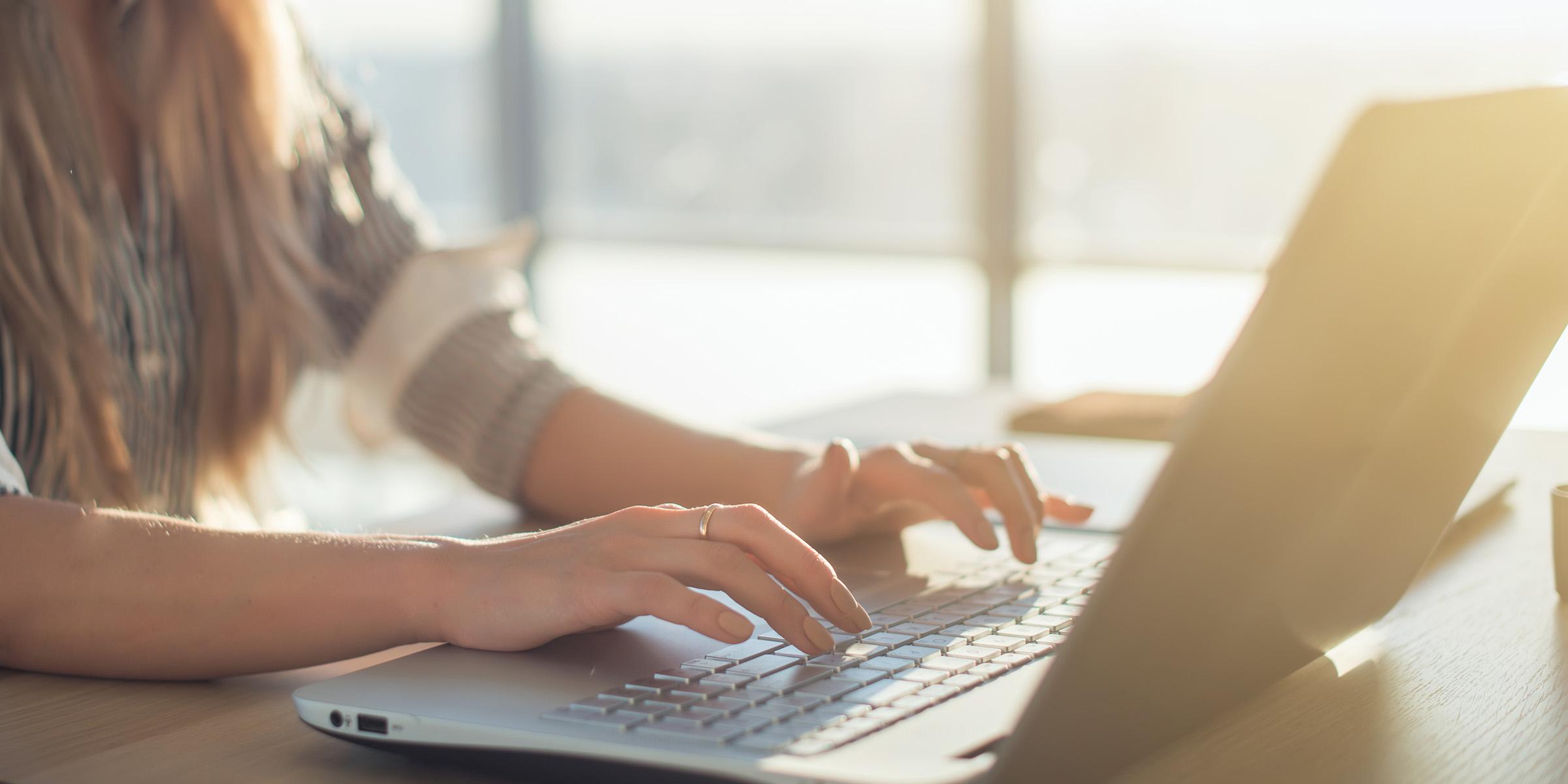 Woman types on laptop