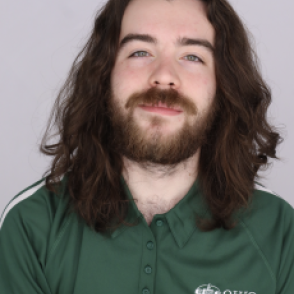 Ian in a dark green Bobcat Student Orientation shirt, smiling at the camera.