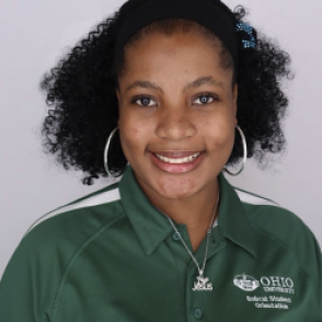 Gloria in a dark green Bobcat Student Orientation shirt, smiling at the camera.