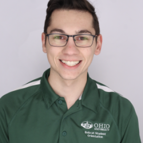 Corey in a dark green Bobcat Student Orientation shirt, smiling at the camera.