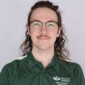 Mason in a dark green Bobcat Student Orientation shirt, smiling at the camera.