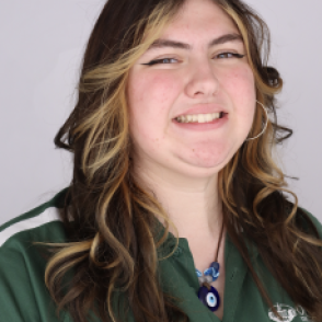 Lil in a dark green Bobcat Student Orientation shirt, smiling at the camera.