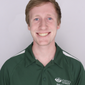 Alex in a dark green Bobcat Student Orientation shirt, smiling at the camera.