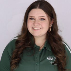 Lucy in a dark green Bobcat Student Orientation shirt, smiling at the camera.