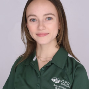 Caroline in a dark green Bobcat Student Orientation shirt, smiling at the camera.