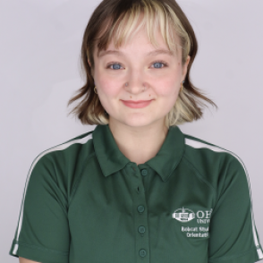 Paige in a dark green Bobcat Student Orientation shirt, smiling at the camera.