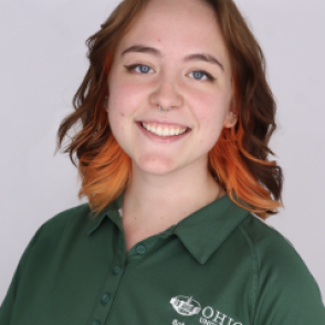 Casey in a dark green Bobcat Student Orientation shirt, smiling at the camera.