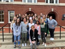 Group of students outside of a brick building