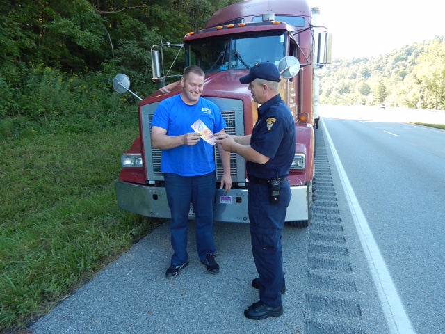 An officer provides a truck driver with educational materials