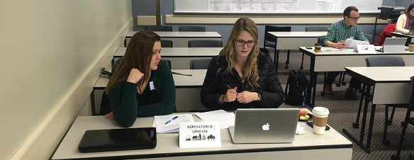 Two students on a class room sitting upfront.