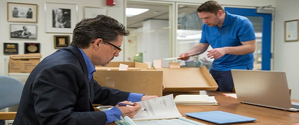(L to R) Voinovich Fellow Robert Baker and staff member David Keller work to process documents in the university archives.