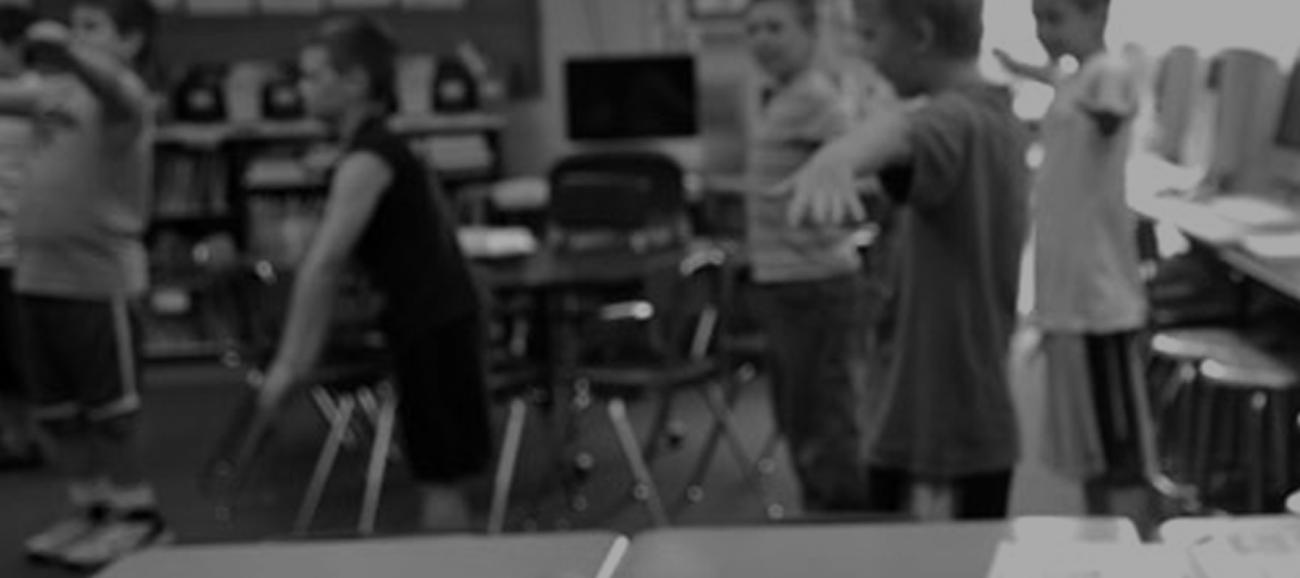 An elementary school classroom with students exercising.