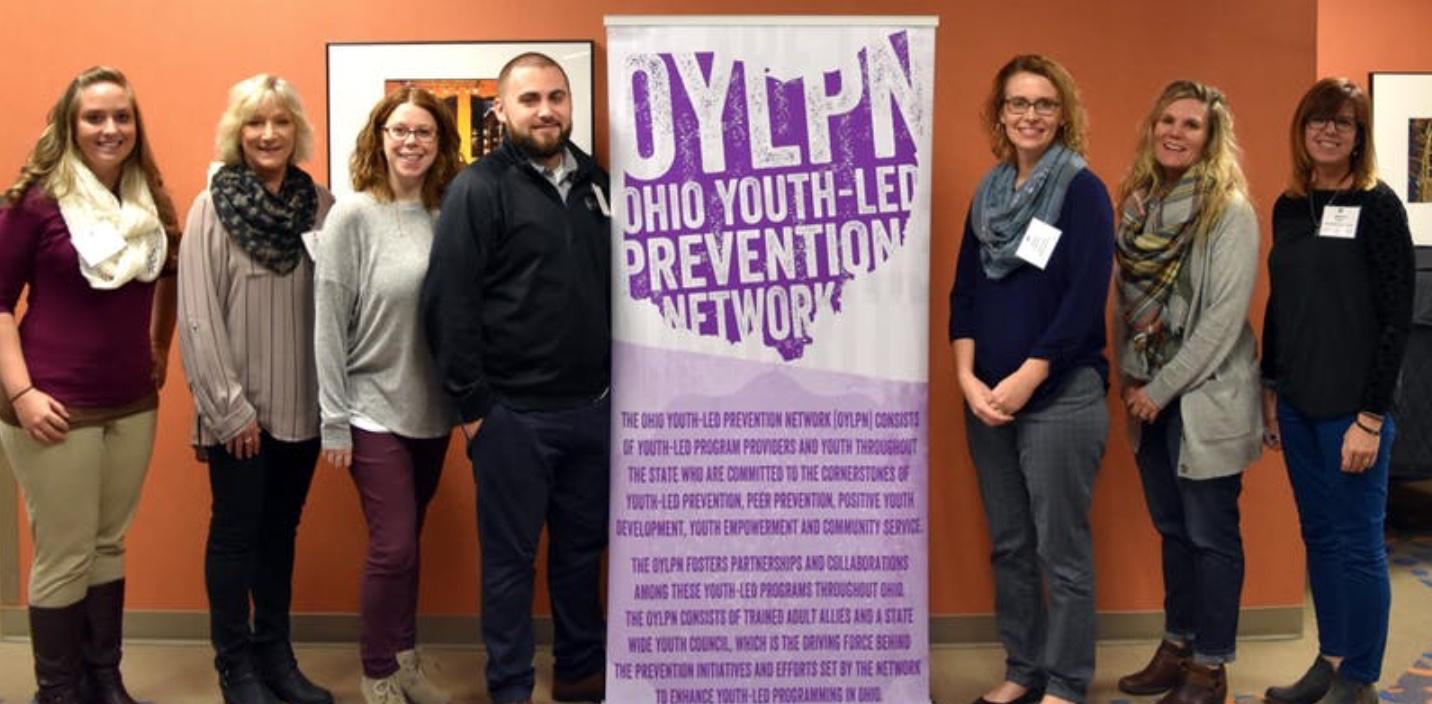 People standing around an Ohio Youth Led Prevention Network banner