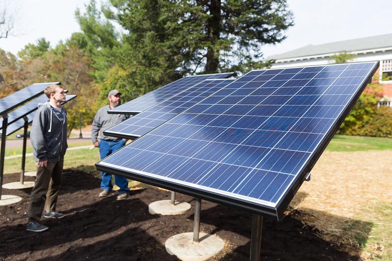 Photo of two students looking at solar panels