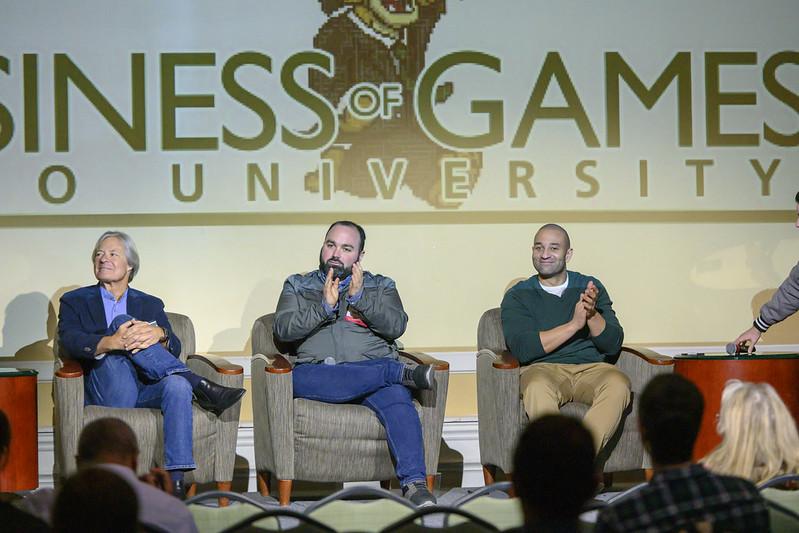 An image of Business of Games Summit from 2019 with three speakers.