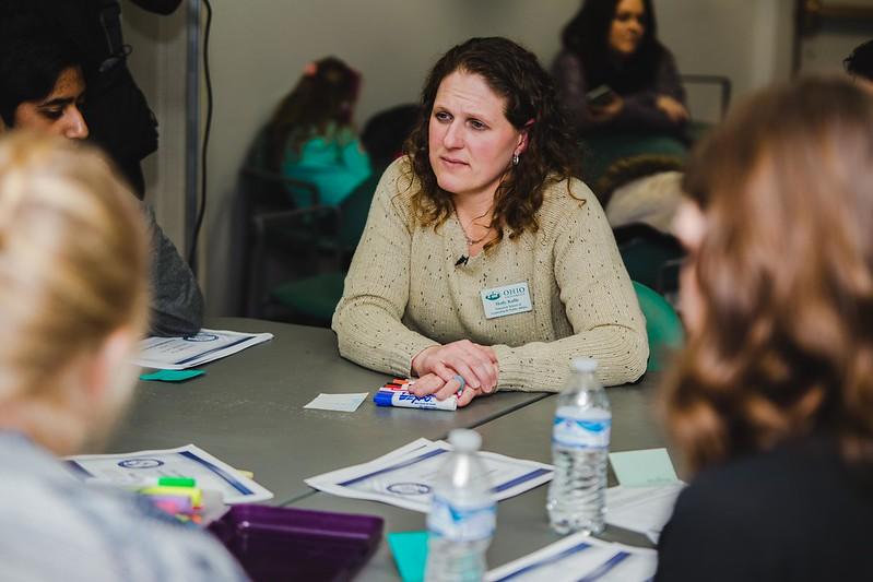 Dr. Holly raffle sits at a table and collaborates with other professionals.